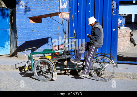 Man sitting on tricycle taxi, Puno, Peru Stock Photo