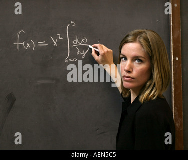 Math Teacher writing on a black board Stock Photo