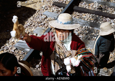 Woman selling gifts on railway track, near La Raya, Puno to Cusco Perurail train journey, Peru Stock Photo