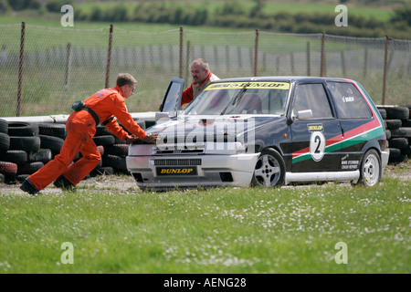 Marshall pushes crashed Fiat Uno at Kirkistown Circuit county down Northern Ireland Stock Photo