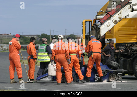 crashed blue Van Diemen RF92 Formula Ford FF 1600 loaded onto recovery truck by marshalls at Kirkistown Circuit county down Stock Photo