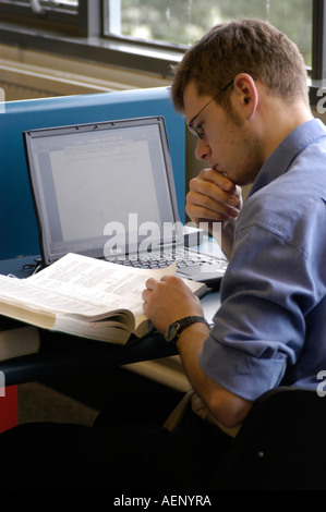 Male student with a laptop computer in library Department of Law Aberystwyth University Ceredigion West Wales UK Stock Photo