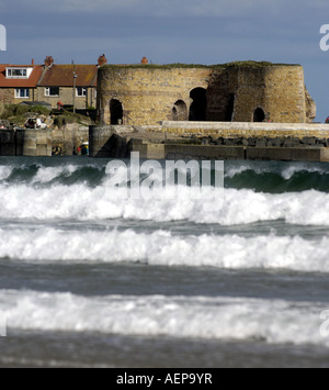 beadnall bay harbour Northumberland  with waves and harbour fort Stock Photo