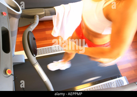 Young woman is training with a treadmill ,Junge Frau laeuft auf einem Laufband in einem Fitnessstudio Stock Photo