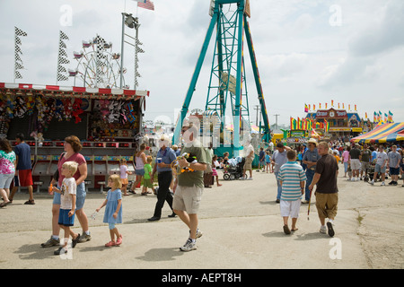 ILLINOIS Grayslake People walk past amusement rides and arcade games at Lake County Fair mother and father with children Stock Photo