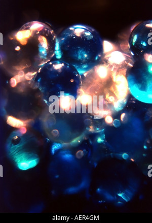 A deep blue abstract of clear and blue marbles in soft focus, and going from light to shadow. Stock Photo