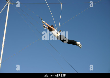 Woman trapeze artist in mid flight Stock Photo