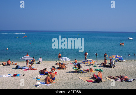 Holiday makers sunbathing on the beach beside the Aegean Sea at Hanioti Kassandria Chalkidiki Greece Stock Photo