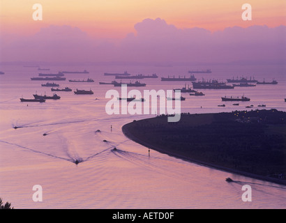 Ships anchored off Singapore at dawn waiting to load or unload at docks Stock Photo