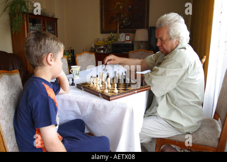 Chess match between young grandson and old grandfather Stock Photo