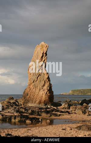 Red rock quartzite sea stacks on the shore at picturesque fishing village, Cullen Bay, Moray coast, Scotland UK Stock Photo