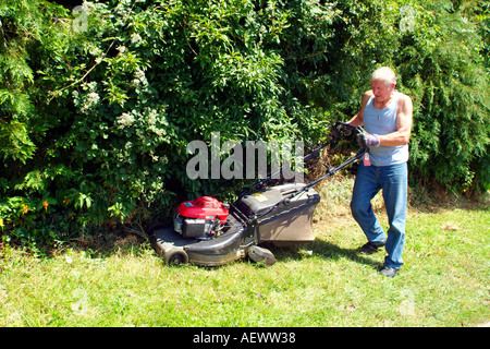 A professional gardener using his rotory lawn mower. Stock Photo