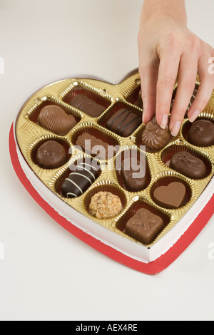 Woman taking a piece of candy from box Stock Photo