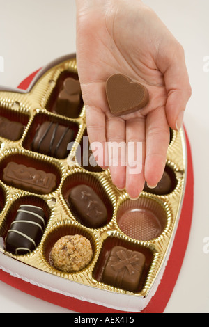 Woman taking a piece of candy from box Stock Photo