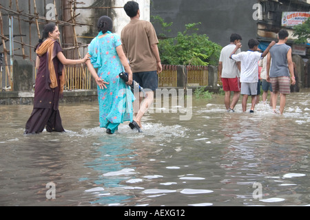 people walking monsoon rainfall water flooded streets Vidyavihar Mumbai ...