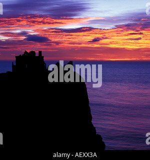 Square format image of a silhouetted Dunnottar castle near stonehaven north east scotland Aberdeen with vibrant sunrise skies. Stock Photo