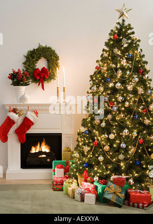 Christmas tree with presents and fireplace with stockings Stock Photo