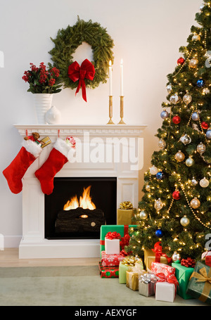 Christmas tree with presents and fireplace with stockings Stock Photo