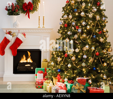 Christmas tree with presents and fireplace with stockings Stock Photo