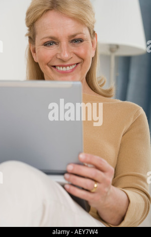 Senior woman using laptop on sofa Stock Photo