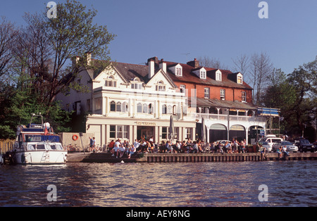 People sitting and drinking outside The Anglers riverside pub and restaurant, overlooking River Thames at Walton on Thames Stock Photo