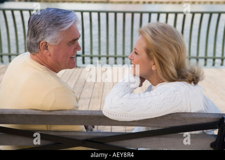 Senior couple sitting on bench outdoors Stock Photo