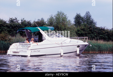 New Chris Craft motor cruiser before reed beds on River Thames above Boveney Lock, Berkshire, England Stock Photo