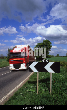 lorry passing black and white chevron signs warning of bend in the road yorkshire uk Stock Photo