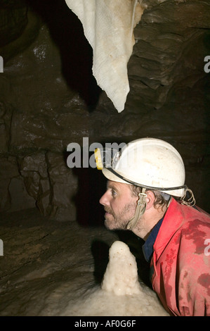 a male caver inspects formations in the newly discovered Notts II cave on Leck fell Yorkshire dales UK Stock Photo