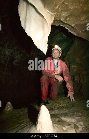 a male caver inspects formations in the newly discovered Notts II cave on Leck Fell Yorkshire Dales Stock Photo