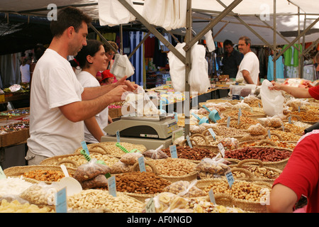 Salesman weighing nuts at the traditional market in the old town of Alcudia, Mallorca, Spain Stock Photo