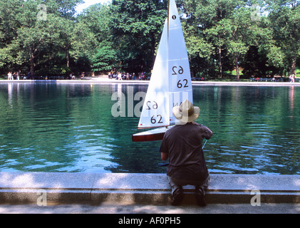 New York City, Central Park Boat Pond, The Conservatory Water. Man with a model toy sailboat. Central Park activities around the Boat Basin. USA Stock Photo