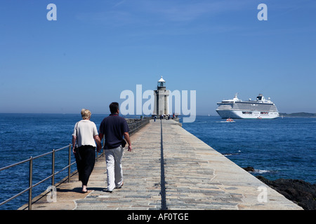 Couple walking along the cobb in Saint Peter Port harbour in Guernsey Channel Islands UK Stock Photo