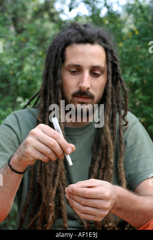 hippy preparing rolling and smoking marijuana joint photos series Stock Photo