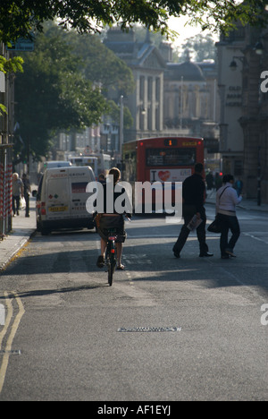 Monday morning scene in Oxford city centre street  with a cyclist and  pedrestrians crossing the road Stock Photo