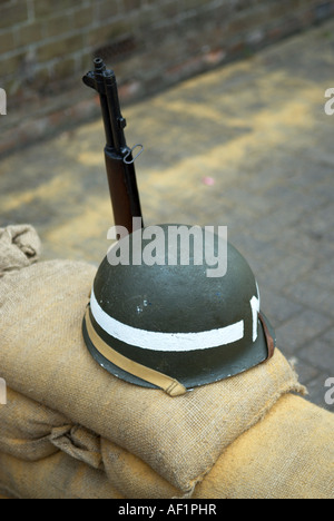 US military police helmet and gun on sandbags circa 1940 WWII Stock Photo