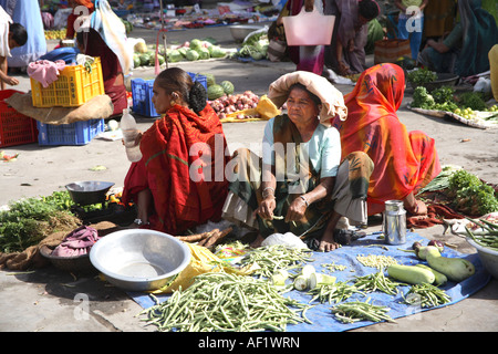 Indian market traders with vegetables laid out on ground in market, Vanakbara Fishing Village, Diu Island, Gujarat, India Stock Photo