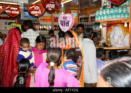 Indian mothers carrying small children standing outside convenience store, Dwarka, Gujarat, India Stock Photo
