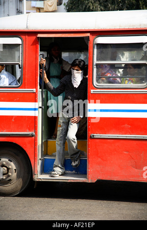 Man on bus with face mask shielding himself from traffic pollution, Pune, India Stock Photo