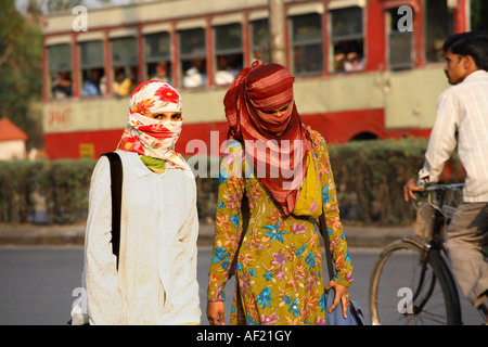 Two Indian women wearing head scarves concealing their faces walking through street, Pune, India Stock Photo