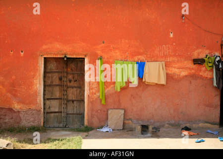 Amazing earth colours of wall, traditional wooden door and drying laundry in historical Indian Jaigarh Fort, near Amer in Jaipur, Rajasthan, India Stock Photo
