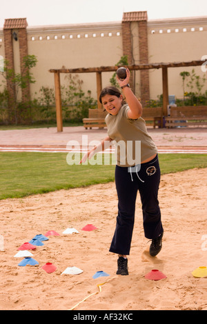 school girl throwing shot putt on school sports day Stock Photo