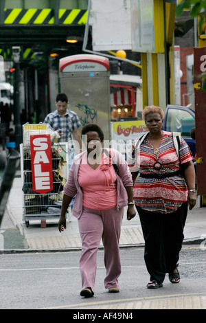 Two West Indian women walk down the street in Finsbury Park London Stock Photo