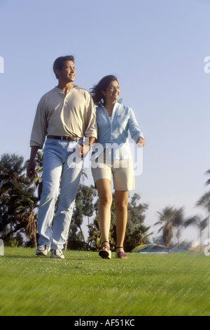 Low angle view of a young couple walking in a park Stock Photo