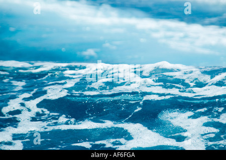 Horizontal close up of the surface of the blue sea being agitated and churned up creating white spray Stock Photo