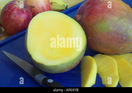 A fresh mango and other fresh fruit which provide essential vitamins and fibre for good health Stock Photo