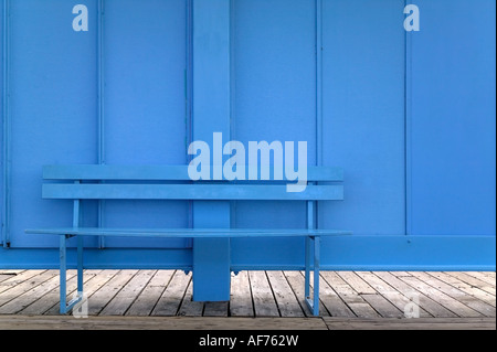 Blue bench against a blue wall Stock Photo