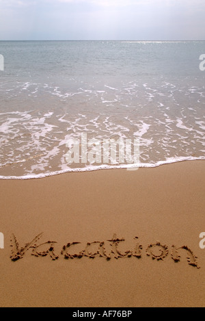 Vacation written in sand on the beach Stock Photo