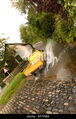 A truck van drives through the ford river crossing in the village of Winsford on Exmoor Stock Photo