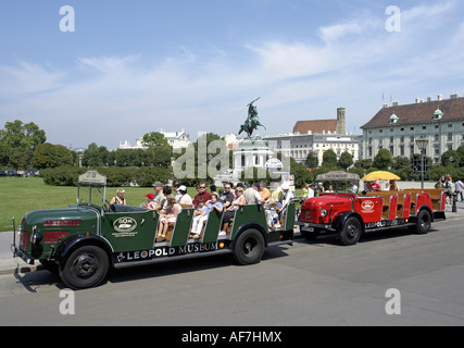 Open sightseeing buses parked at Heldenplatz Hofburg in the centre of Vienna with statue of Archduke Karl behind Stock Photo